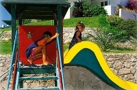 Children playing in the Golden Milos Beach Hotel playground, Provatas, Milos, Cyclades, Greece
