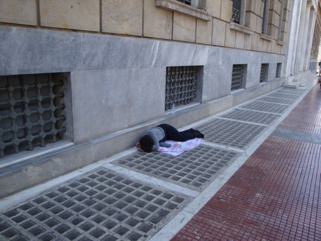 Homeless person in front of Greek bank